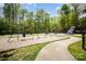 Community playground with swings, slides, and climbing structures in a wooded area at 1801 Briarcrest Nw Dr, Charlotte, NC 28269