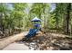 Well-maintained community playground with slide and climbing features surrounded by trees and fencing at 1801 Briarcrest Nw Dr, Charlotte, NC 28269