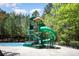 Community pool featuring slide, tower, pool furniture, and mature trees at 1801 Briarcrest Nw Dr, Charlotte, NC 28269