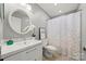 Well-lit bathroom featuring a modern vanity, round mirror, and a shower with a decorative curtain at 181 Riverview Ter, Clover, SC 29710