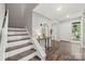 A stairway leads to the upper floors, near a decorative console table and entry way at 181 Riverview Ter, Clover, SC 29710