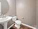 Comfortable half bathroom with a pedestal sink, modern toilet, and wood-look flooring at 1907 Caprington Dr, Fort Mill, SC 29707