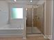Bright bathroom featuring a separate shower and soaking tub illuminated by a window, with tile throughout at 1907 Caprington Dr, Fort Mill, SC 29707