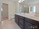 Bathroom featuring double sinks, dark cabinets and a glass shower at 1907 Caprington Dr, Fort Mill, SC 29707