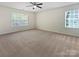Spacious carpeted bedroom with two windows allowing natural light, plus a ceiling fan to keep you cool at 1907 Caprington Dr, Fort Mill, SC 29707