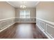 Elegant dining room with wainscoting, crown molding, chandelier, and wood-look flooring at 1907 Caprington Dr, Fort Mill, SC 29707