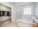 Bright bathroom with a soaking tub, a glass shower, and a walk-in closet at 2003 Ptarmigan Ct, Waxhaw, NC 28173