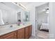 Bright bathroom featuring a double sink vanity and a view into the bedroom at 2003 Ptarmigan Ct, Waxhaw, NC 28173