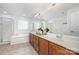 Bright bathroom with dual sinks, wood cabinets, and a separate tub and shower at 2003 Ptarmigan Ct, Waxhaw, NC 28173