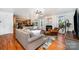 Open-concept living room with hardwood floors, a fireplace, views into kitchen, and casual seating at 2003 Ptarmigan Ct, Waxhaw, NC 28173