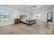 Tranquil main bedroom with neutral tones, a tray ceiling, and ample natural light from two windows at 2003 Ptarmigan Ct, Waxhaw, NC 28173