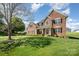 Spacious brick home with a large front yard, lush green lawn, and mature tree at 2003 Ptarmigan Ct, Waxhaw, NC 28173