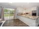 Bright kitchen with granite countertops, white cabinetry, and sliding glass doors leading to a backyard patio at 22025 Torrence Chapel Rd, Cornelius, NC 28031