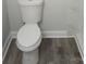 Modern bathroom with a white toilet and wood-look flooring, creating a clean, updated space at 2822 Royston Rd, Charlotte, NC 28208