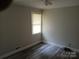 This bedroom is a blank canvas with newly installed wood flooring and window letting in natural light at 2822 Royston Rd, Charlotte, NC 28208