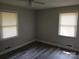 This bedroom has newly installed flooring and large windows that allow natural light to flow into the space at 2822 Royston Rd, Charlotte, NC 28208