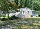 Charming single-story home with white brick, light blue siding, and a well-manicured lawn surrounded by mature trees at 2822 Royston Rd, Charlotte, NC 28208