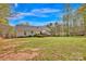 Grassy backyard with a deck, lush lawn, and trees at 2895 Sweeping Pine Ln, Denver, NC 28037