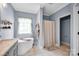 Modern bathroom featuring soaking tub, grey walls, and neutral tile floors at 2895 Sweeping Pine Ln, Denver, NC 28037