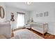 Bright Bedroom featuring a white crib, a changing table, and light colored wood flooring at 2895 Sweeping Pine Ln, Denver, NC 28037