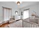 Bright Bedroom featuring a white crib, changing table, and decorative accents at 2895 Sweeping Pine Ln, Denver, NC 28037