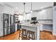 Stylish kitchen with white cabinets, stainless steel appliances, a granite island with bar seating, and pendant lighting at 2895 Sweeping Pine Ln, Denver, NC 28037