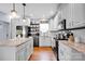 Well-lit modern kitchen boasting white cabinetry, stainless steel appliances, granite countertops, and hardwood floors at 2895 Sweeping Pine Ln, Denver, NC 28037