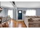 Spacious living area with hardwood floors, connecting to a dining area and a front entry door, all with a modern design at 2895 Sweeping Pine Ln, Denver, NC 28037