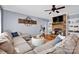Inviting living room with a cozy fireplace, built-in shelving, comfortable seating, and modern ceiling fan at 2895 Sweeping Pine Ln, Denver, NC 28037