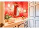 Stylish bathroom with red patterned wallpaper, marble countertops and ornate sconces at 316 Country Club Acres None, Shelby, NC 28150