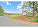 Community entrance sign with brickwork and mature trees alongside well-maintained landscaping and beautiful blue skies at 316 Country Club Acres None, Shelby, NC 28150