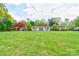 Expansive lawn, mature trees, and colorful landscaping frame the exterior of this estate home with center double door entry at 316 Country Club Acres None, Shelby, NC 28150