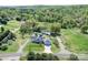 A charming blue home with an attached garage sits amidst lush greenery and trees in this aerial view at 3241 Long Shoals Rd, Lincolnton, NC 28092