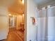Traditional bathroom featuring wood floors, beadboard, and classic fixtures and a tub with shower curtain at 3241 Long Shoals Rd, Lincolnton, NC 28092