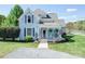 Charming blue two-story home with a welcoming front porch, gravel driveway, and well-manicured lawn at 3241 Long Shoals Rd, Lincolnton, NC 28092
