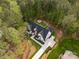 Aerial view of a stunning home featuring a modern farmhouse design with manicured lawn, long driveway, and fire pit at 3268 Sherman Dr, Lancaster, SC 29720