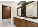 Bathroom with double sinks, bronze fixtures, dark accent wall, and a door leading to a separate toilet and shower area at 3268 Sherman Dr, Lancaster, SC 29720