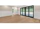 A spacious bedroom with wainscotting, wood flooring, and large black-framed glass doors leading to a private balcony at 3268 Sherman Dr, Lancaster, SC 29720