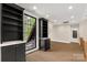 A large bonus room is enhanced by natural light from the large window, black built-ins, and wood flooring at 3268 Sherman Dr, Lancaster, SC 29720