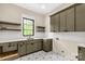 This functional laundry room includes shaker cabinets, open shelving and a sink with modern fixtures and geometric tile flooring at 3268 Sherman Dr, Lancaster, SC 29720