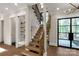 Modern wooden staircase with iron railing, glass enclosed wine storage and front door at 3268 Sherman Dr, Lancaster, SC 29720