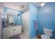 Well-lit blue bathroom with a vanity, mirror, shower with curtain, and a toilet at 3622 Roxburgh Ln, Gastonia, NC 28056