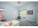 A cozy bedroom with a bright blue palette, featuring neutral carpet, white trim, and a window view for a cheerful space at 3622 Roxburgh Ln, Gastonia, NC 28056