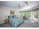 A sunny bedroom with large windows, a patterned duvet, and a ceiling fan, perfect for relaxation and rest at 3622 Roxburgh Ln, Gastonia, NC 28056