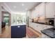 Bright kitchen featuring white cabinets, stainless steel appliances, hardwood floors, and a blue island at 3622 Roxburgh Ln, Gastonia, NC 28056