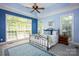 A cozy bedroom featuring a blue accent wall, a decorative rug, and large windows providing ample natural light at 3622 Roxburgh Ln, Gastonia, NC 28056