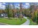 Stunning brick home featuring mature trees, a lush green lawn, and a winding driveway in a beautiful wooded setting at 4071 Poplar Ridge Dr, Fort Mill, SC 29715