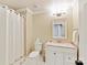 A well-lit bathroom features decorative wallpaper, tiled floors, and a vanity with storage at 4407 Coventry Row Ct, Charlotte, NC 28270