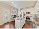 Well-lit kitchen with an island, stainless steel appliances, white cabinetry, and hardwood floors at 4407 Coventry Row Ct, Charlotte, NC 28270