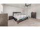 Spacious bedroom with a ceiling fan, neutral carpet, and classic furnishings including a dresser and nightstand at 4538 Opus Ln, Charlotte, NC 28214